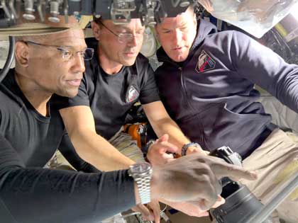 Navy Capt. Victor Glover, spacecraft pilot, retired Navy Capt. Reid Wiseman, Artemis II mission commander, and Jeremy Hansen, mission specialist, prepare for their journey around the far side of the moon by configuring their camera equipment shortly before beginning their lunar flyby observations, April 6, 2026. Courtesy photo.